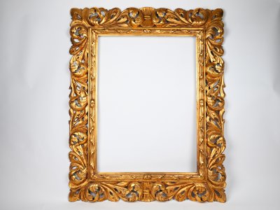 A RICHLY CARVED BAROQUE STYLE PICTURE FRAME