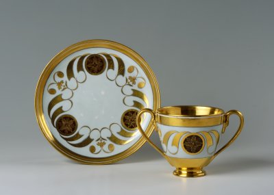 A TWO-HANDLE CHOCOLATE CUP WITH SAUCER