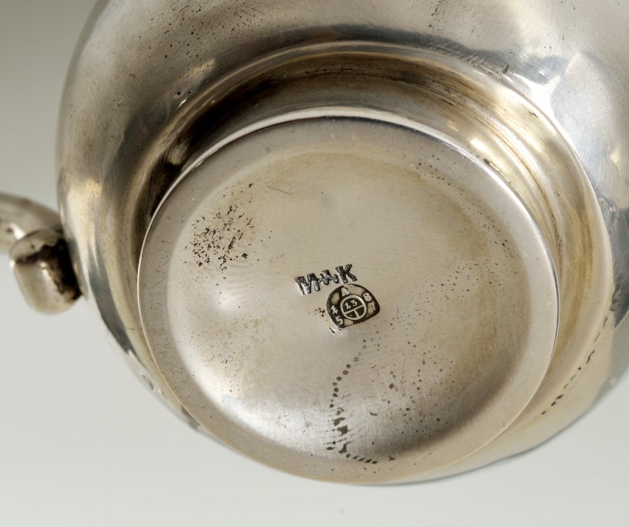 A SILVER KETTLE WITH A WARMER