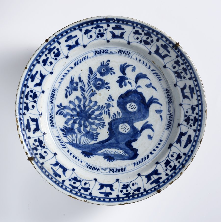 A GROUP OF TWO FAÏENCE PLATES WITH A ROSETTE AND EVERLASTING FLOWERS