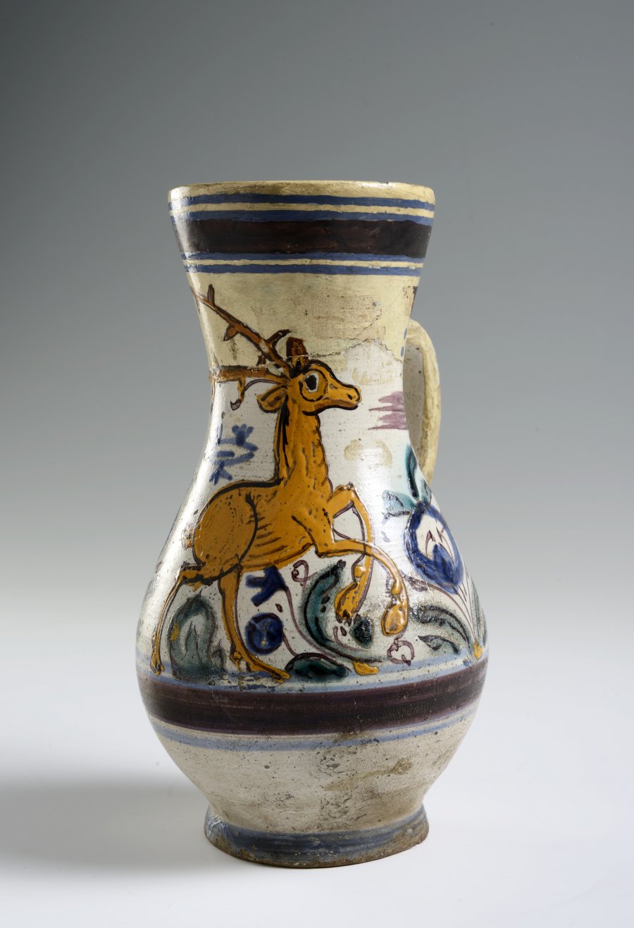 A PAIR OF TWO FOLK ART PITCHERS WITH FLOWER MOTIFS AND STAG