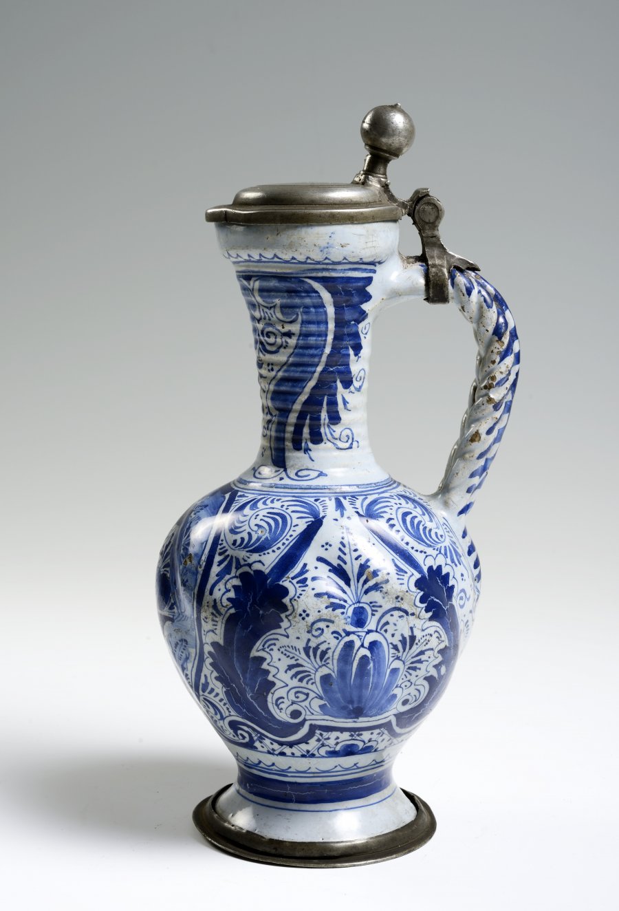 A FAÏENCE PITCHER WITH A PEWTER LID