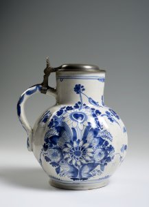 A FAÏENCE PITCHER WITH A PEWTER LID