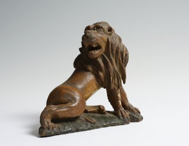 A CARVED WOOD FIGURE OF A SEATED LION