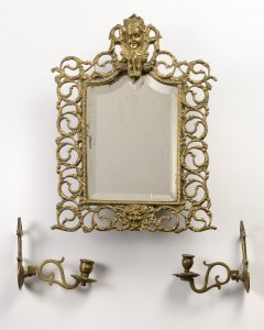 A SMALL MIRROR WITH TWO HANGING CANDLE HOLDERS