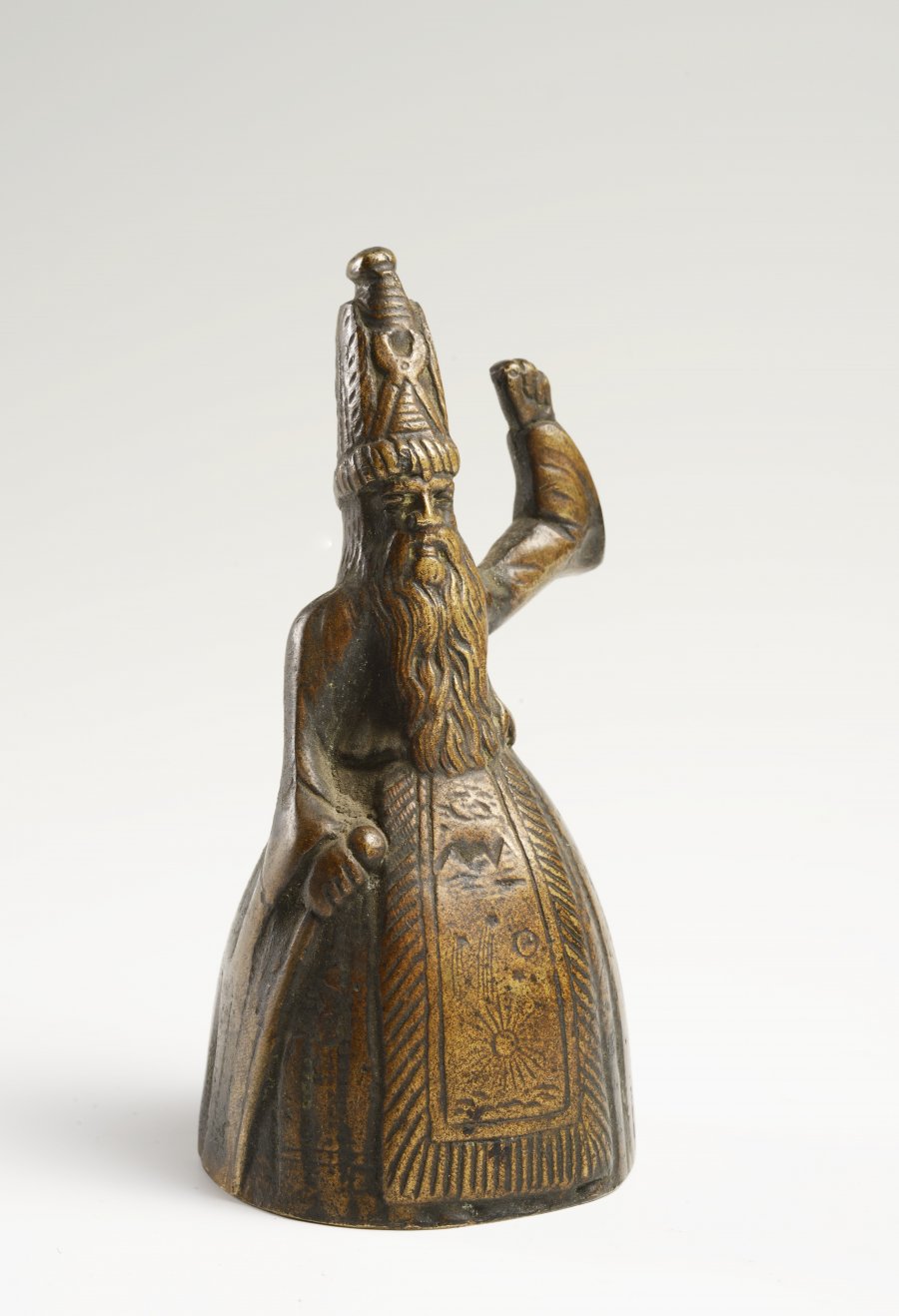 A SMALL BRONZE BELL IN THE FORM OF A STANDING PERSIAN