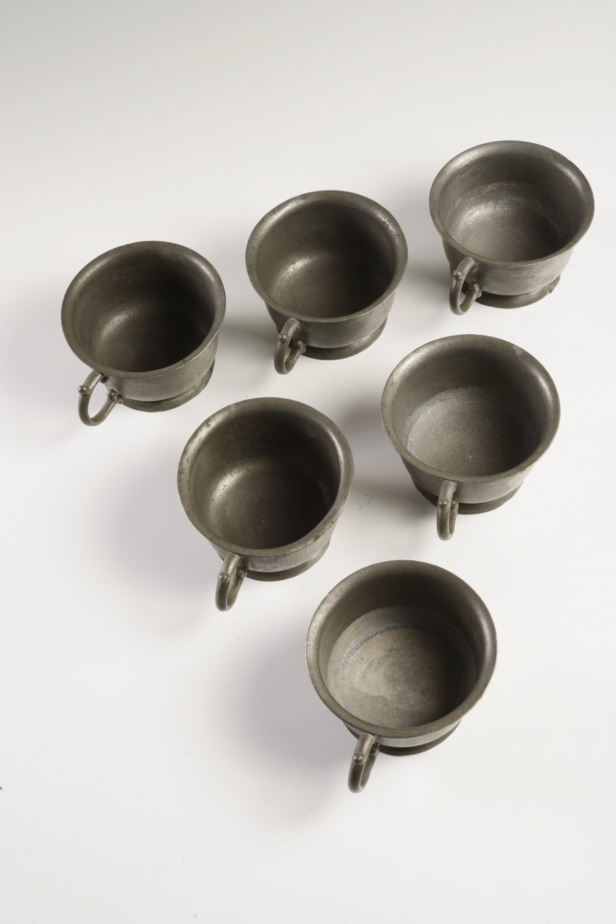 A GROUP OF PEWTER TABLEWARE - TWO STEINS, SIX BOWLS WITH HANDLES